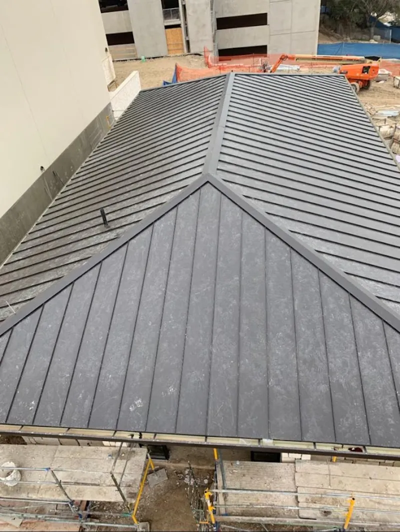 Commercial metal roof construction with crane equipment in Tice